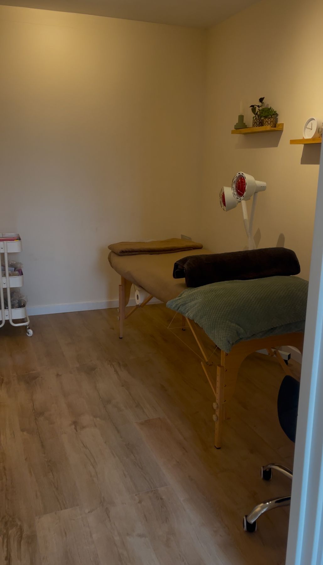 Behandelkamer met behandeltafel en rode warmtelamp