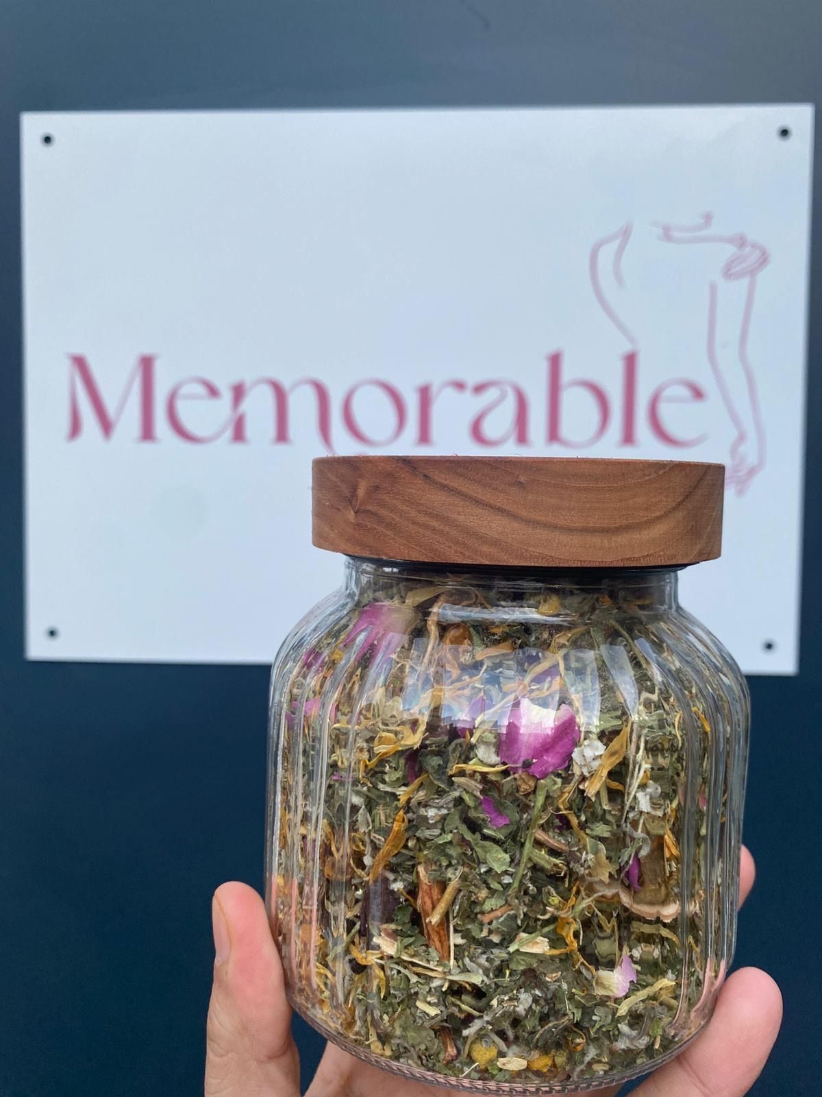 Een glazen pot met gedroogde kruidenthee met rozenknopjes en goudsbloem