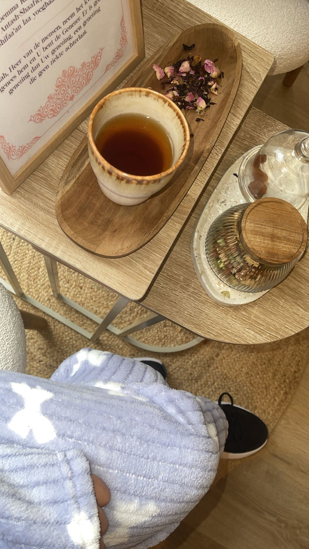 Een kop thee en rozenknopjes op een houten plankje, na een behandeling